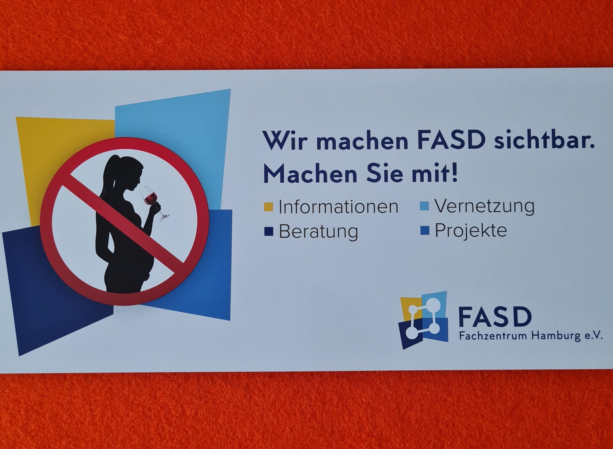 Karte: Grafik: Schwangere mit einem Weinglas in der Hand, wie in einem Verkehrszeichen durchgestrichen. TExt: Wir machen FASD sichtbar. Machen Sie mit?