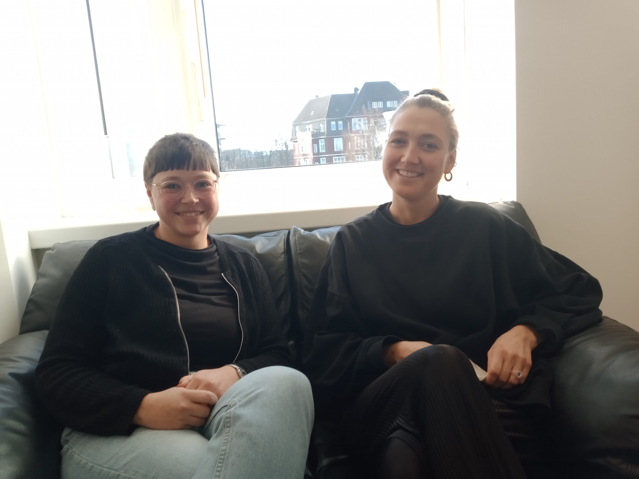 Links im Bild ist Gesa Müller, rechts Swantje Borsutzky. Die beiden sitzen auf einem Sofa in der Geschäftsstelle der Lebenshilfe Hamburg.