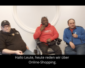 Drei junge Männer sitzend, einer davon im Rollstuhl.